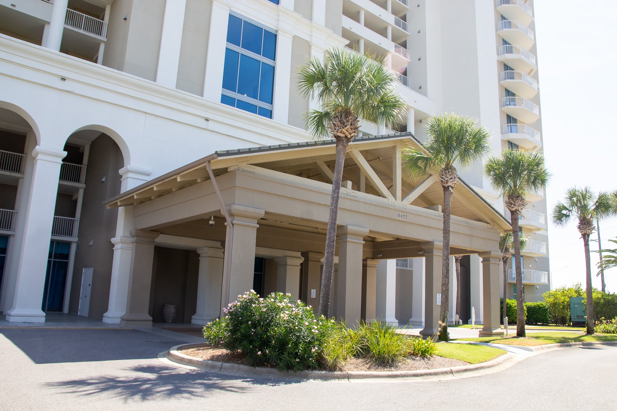 Marina Landing condos front entrance in Panama City Beach Florida with palm trees on the front lawn